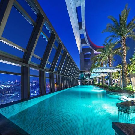 Caesar Park Hotel Banqiao Taipei Exterior photo The photo depicts a luxurious swimming pool situated in a high-rise building, showcasing a stunning view of the city beneath. The pool is illuminated by soft lighting, giving it a tranquil ambiance. Surrounding the pool are modern architectural eleme