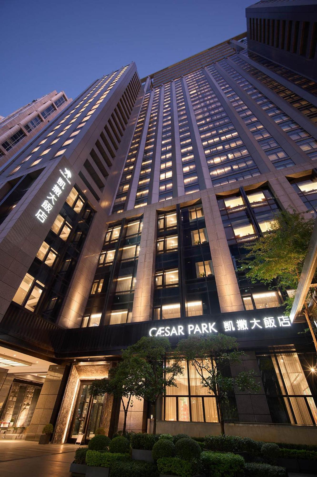 Caesar Park Hotel Banqiao Taipei Exterior photo The photo shows a modern high-rise building, which appears to be a hotel named "Caesar Park." The building has multiple floors with large windows, and the exterior is designed with a combination of glass and stone materials. Illuminated signage in bo