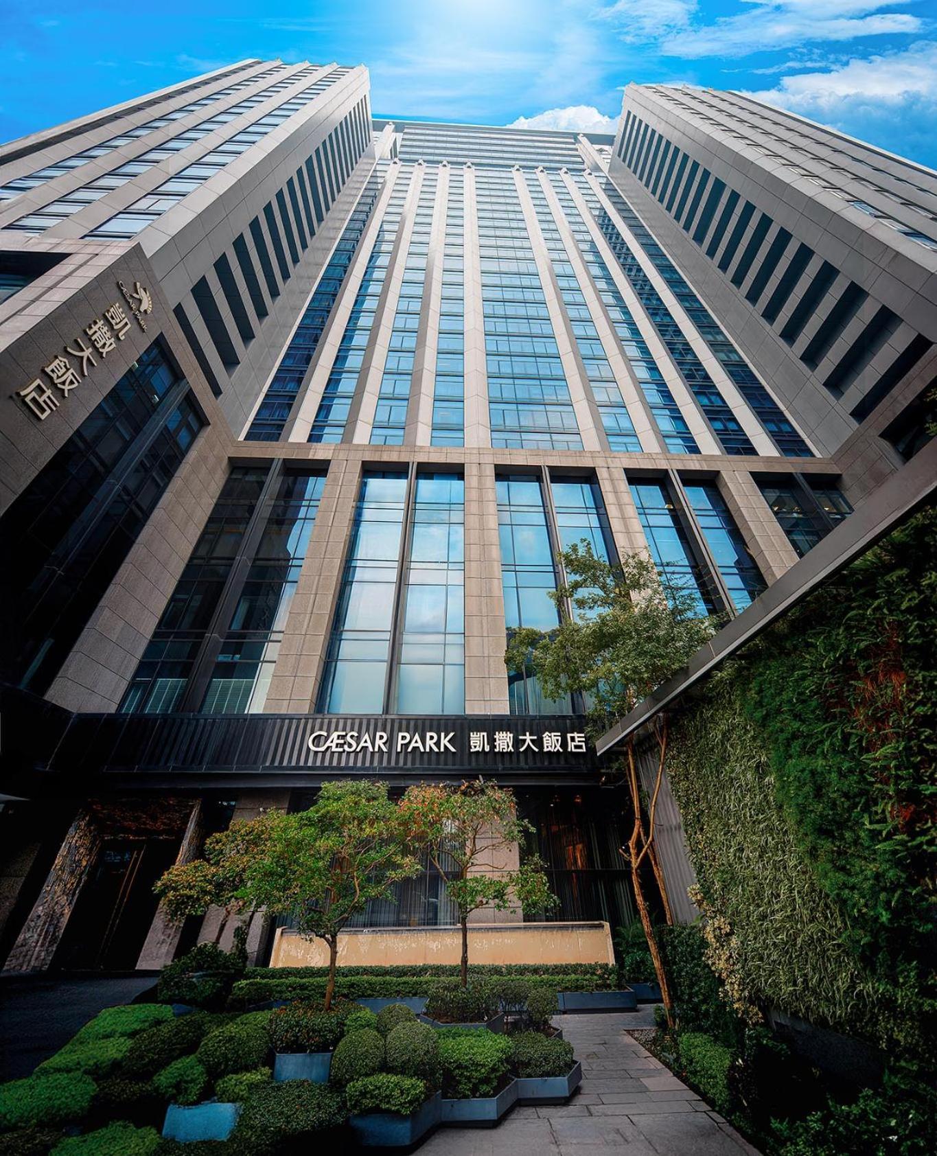 Caesar Park Hotel Banqiao Taipei Exterior photo The image shows a modern high-rise building featuring a glass facade. The structure is tall and has a sleek, contemporary design with numerous windows reflecting the surroundings. At the base of the building, there is a sign that reads "CAESAR PARK" 